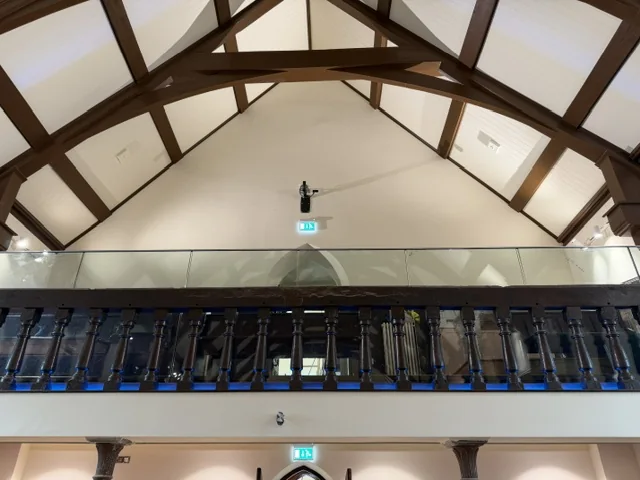 Restored gallery with illuminated historic balusters and protective glazing