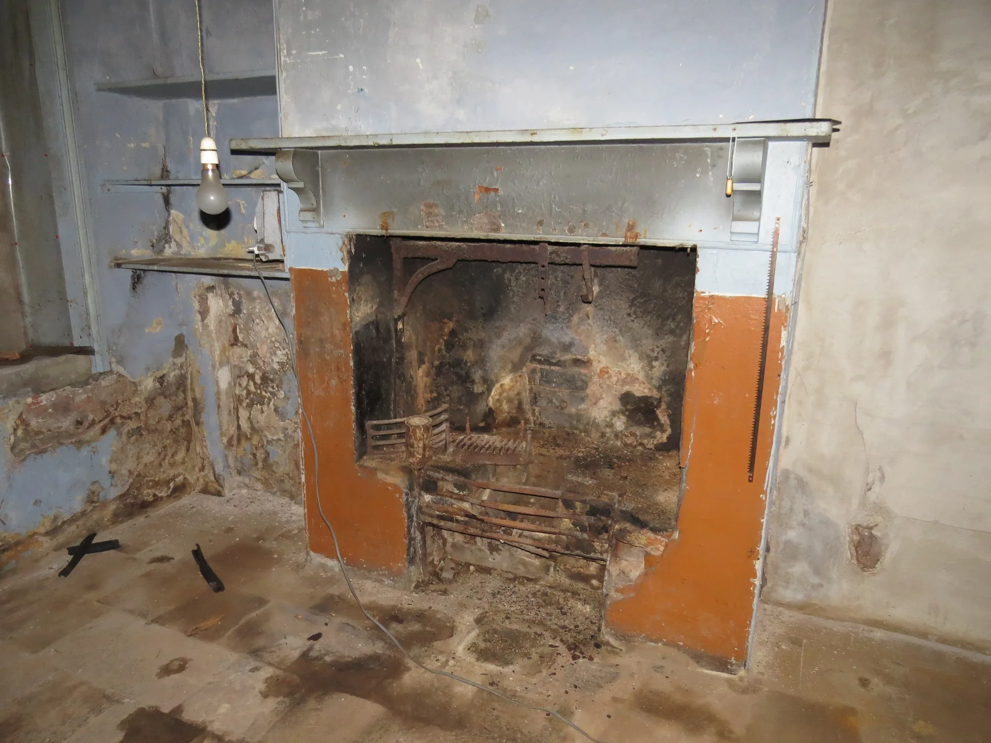 Water-damaged fireplace and interior before restoration