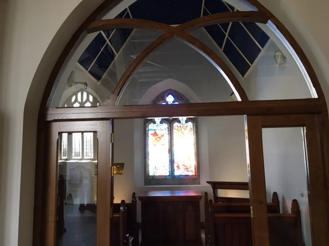 Glazed timber screen and stained-glass window at St Colman’s