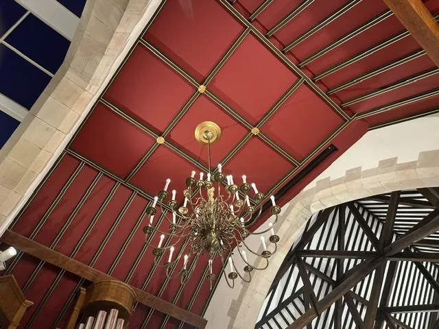 Restored red decorative ceiling and chandelier at St Colman’s